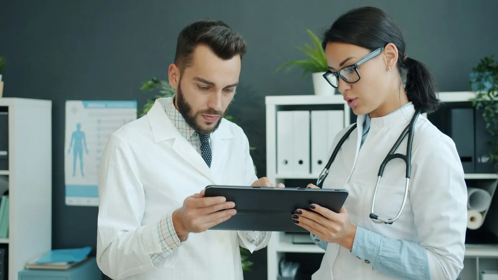 Two clinicians reviewing patient flow on a tablet